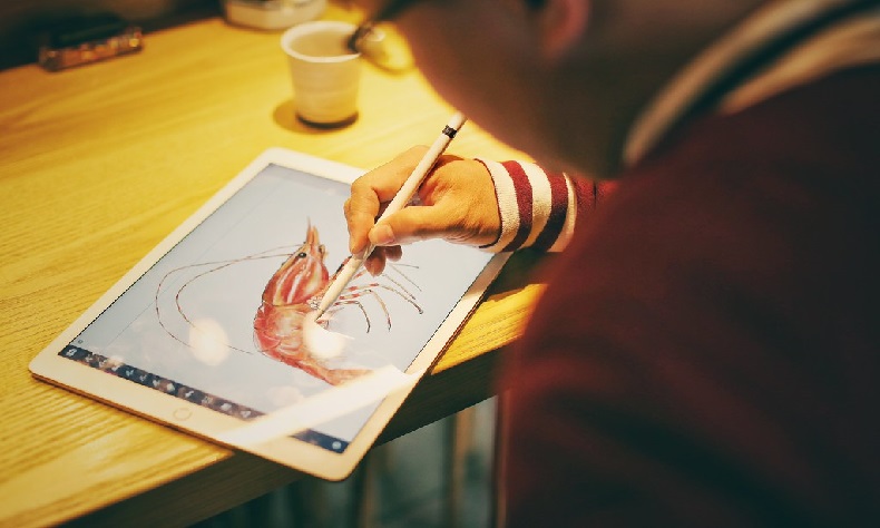 a person drawing on a iPad